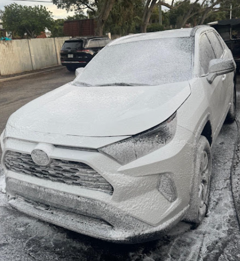 SUV covered in thick cleaning foam during an exterior wash